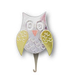 A silver-colored needle threader in the shape of an owl with gold and white details on a magnetized base.