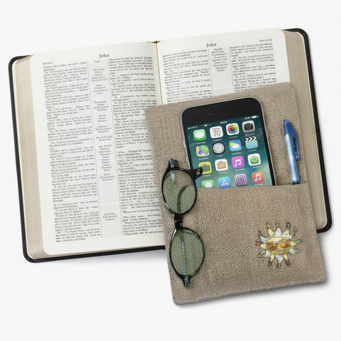 Notebook with phone, sunglasses, and decorative items on a white background